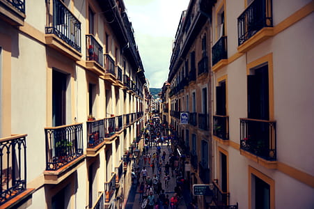people walking along street between concrete buildings thumbnail