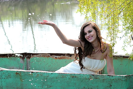woman in teal boat raising right hand thumbnail