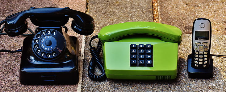 photo of two telephone and cordless phone with dock on surfaec thumbnail