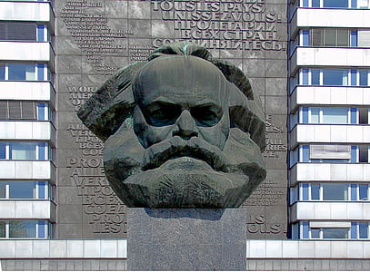 man's head statue on top of block near building thumbnail
