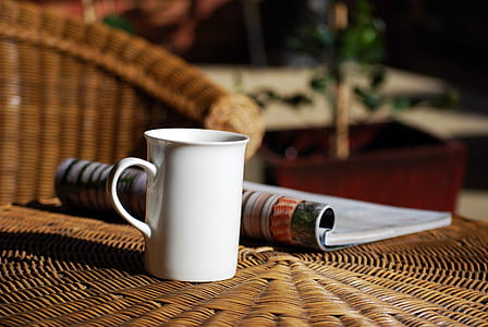 shallow focus photography of white ceramic mug on brown wicker table thumbnail