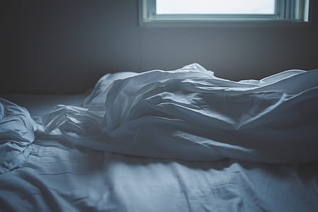 ruffled white blanket and bedspread beside window thumbnail