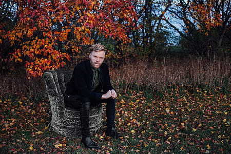 man in black suit jacket sitting on chair thumbnail