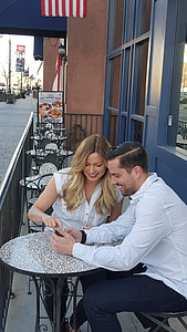 man and woman sitting on bistro chairs thumbnail