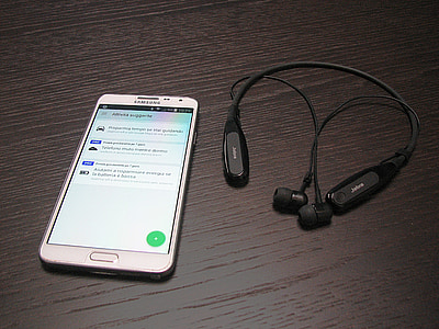 white Samsung Android smartphone beside stereo neckband headphones thumbnail