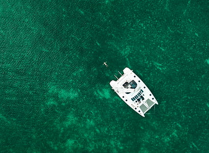 aerial view of white boat on green sea thumbnail