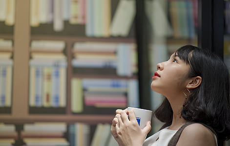Woman Wearing White Shirt Looking on Top Holding White Ceramic Mug thumbnail