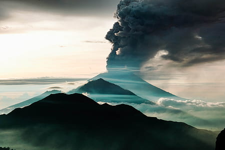 silhouette photo of volcano under cloudy sky thumbnail