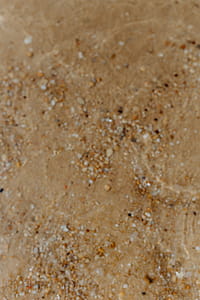 Sand beach background with sea shells & pebbles - many round small stones thumbnail