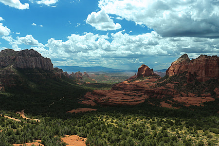 brown and green mountains under cloudy blue sky during daytime thumbnail