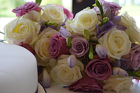 white and purple rose bouquet on top of white table thumbnail