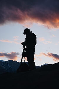 silhouette of standing man under orange sky thumbnail