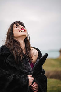 selective focus photo of woman holding black coat thumbnail