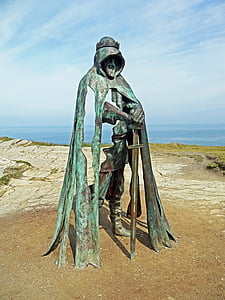 man holding sword statue during daytime thumbnail