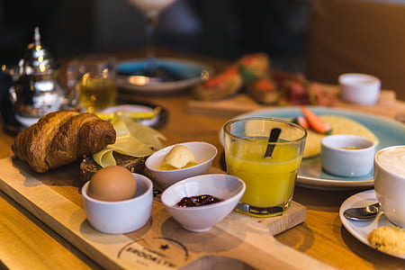 bread on chopping board beside white ceramic bowls display on table thumbnail
