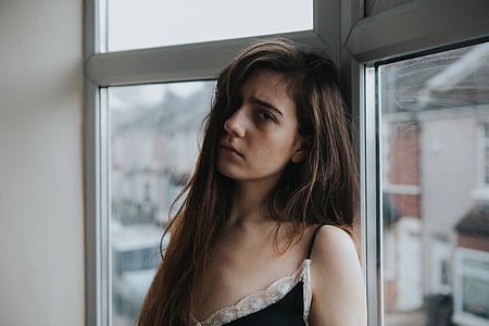 woman leaning on window inside house thumbnail