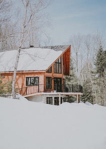 brown wooden 2-storey house covered with snow thumbnail