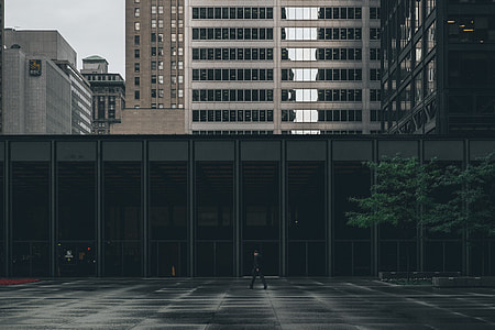 man walking in front of building during day thumbnail