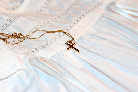 gold-colored cross pendant necklace on white textile \ thumbnail