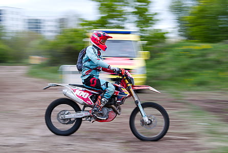 person riding red and silver dirt bike during daytime thumbnail