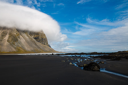 black sand near body of water during daytime thumbnail