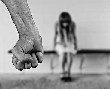 grayscale photo of human hand with girl in the background thumbnail