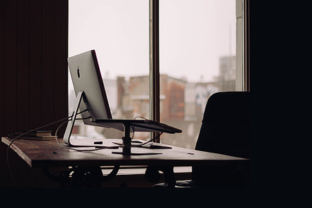 selective focus photography of monitor on desk near window pane thumbnail