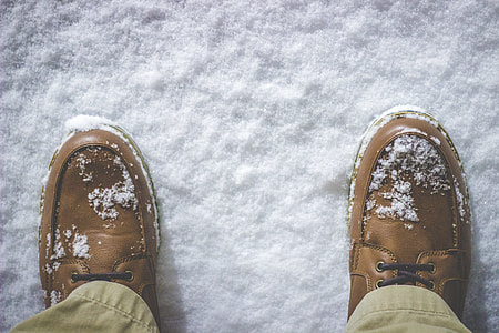 person wearing brown leather shoes standing on white snow field thumbnail
