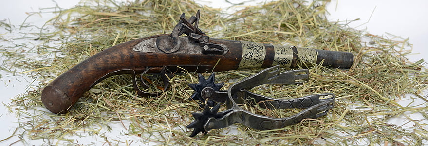 brown and black flintlock pistol and black metal spur thumbnail