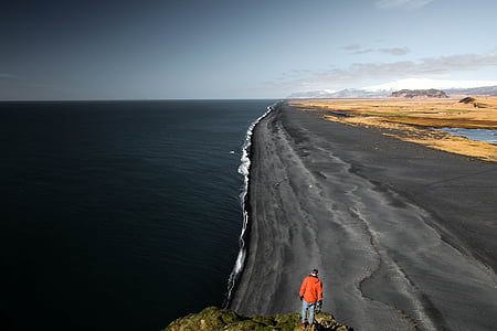 person in orange top on rock formation thumbnail