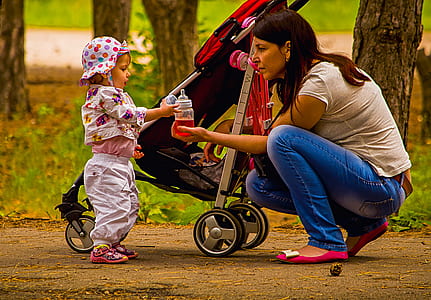 woman sitting in front of child beside stroller thumbnail