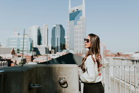 woman standing in front of rail over viewing high rise building thumbnail