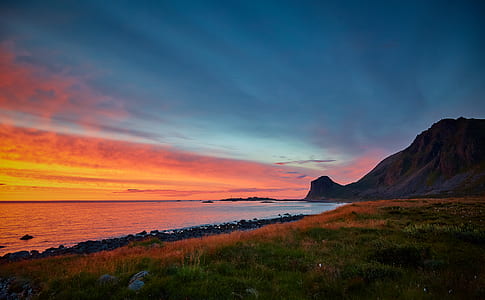 body of water near rock formation during sunset thumbnail