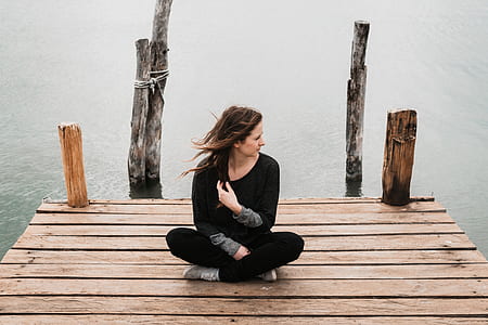 woman sitting at edge on wooden dock thumbnail
