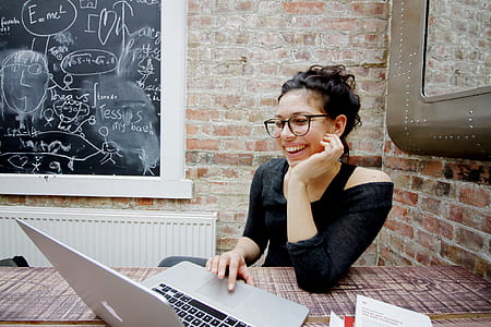 woman wearing black shirt seating wile using laptop thumbnail