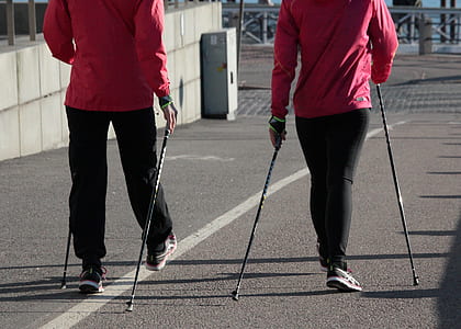 two person standing holding metal sticks on road thumbnail