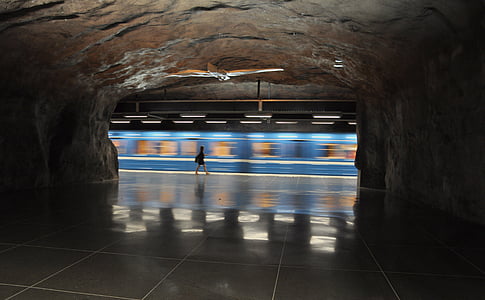 panning photography of woman walking near train thumbnail