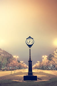 photo of pedestal clock on road at nighttime thumbnail