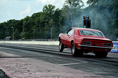 red muscle car on drag strip during daytime thumbnail