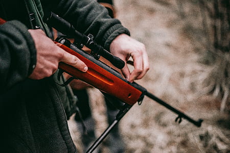 person holding brown and black hunting rifle thumbnail