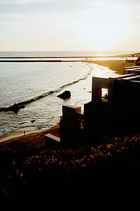 building near shoreline during golden hour thumbnail