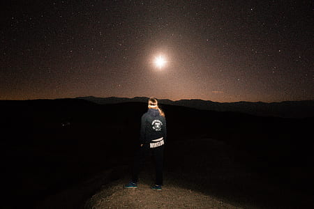 person standing on mountain during midnight thumbnail