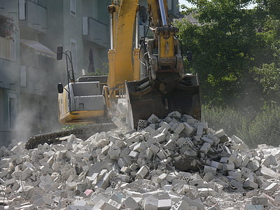 yellow and black excavator unloading gray debris during daytime thumbnail
