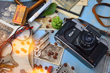 Black and Gray Dslr Camera Beside Three Gray Skeleton Keys thumbnail