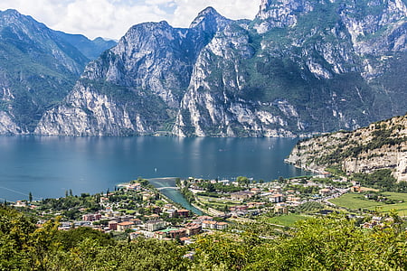 bird's eye photography of structures and mountains surrounding lake thumbnail
