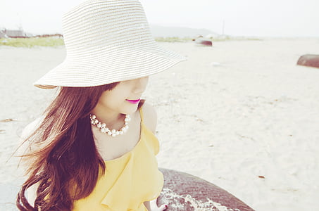 photography of sitting woman wearing summer hat during daytime thumbnail