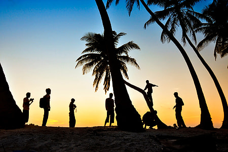 People enjoying the palm-tree beach at sunset in the Maldives thumbnail