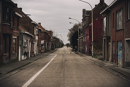 grey concrete road with brown houses on the sides thumbnail