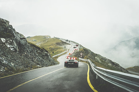 Sport Cars on Wet Mountain Road in Rainy Weather thumbnail