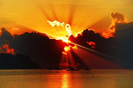 silhouette photography of calm water under crepuscular ray thumbnail